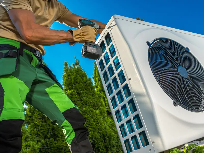 Groupe extérieur de climatisation en cours d'installation par un technicien