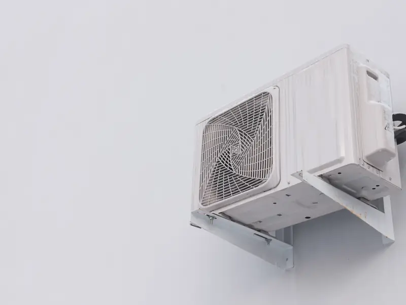Groupe extérieur de climatisation fixé sur un support mural à l'arrière d'un commerce