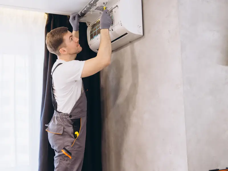 Réparation d'une climatisation murale fixée en hauteur, en pleine saison chaude