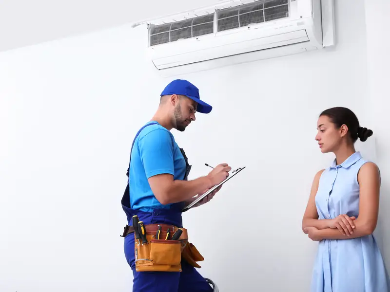 Technicien expliquant à une cliente l'origine de la panne de sa climatisation