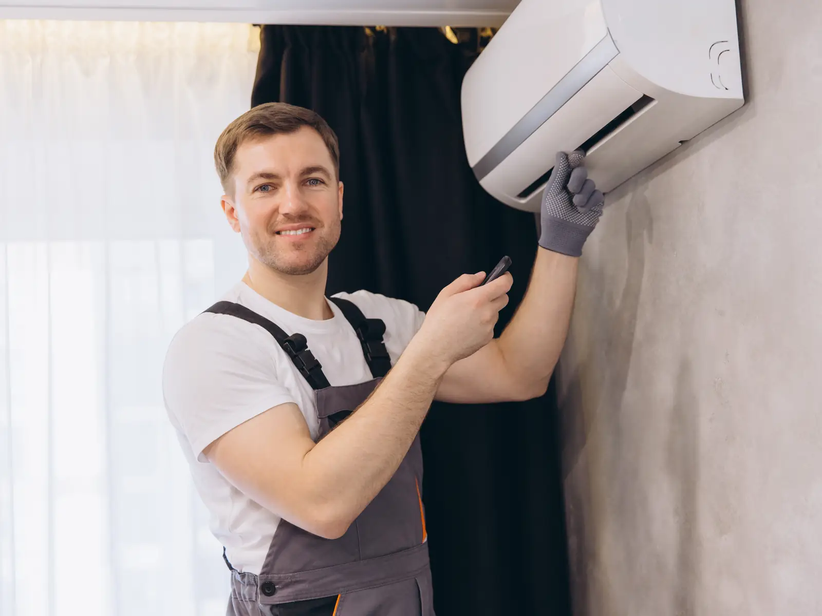 Technicien réparant une unité intérieure de climatisation restée éteinte
