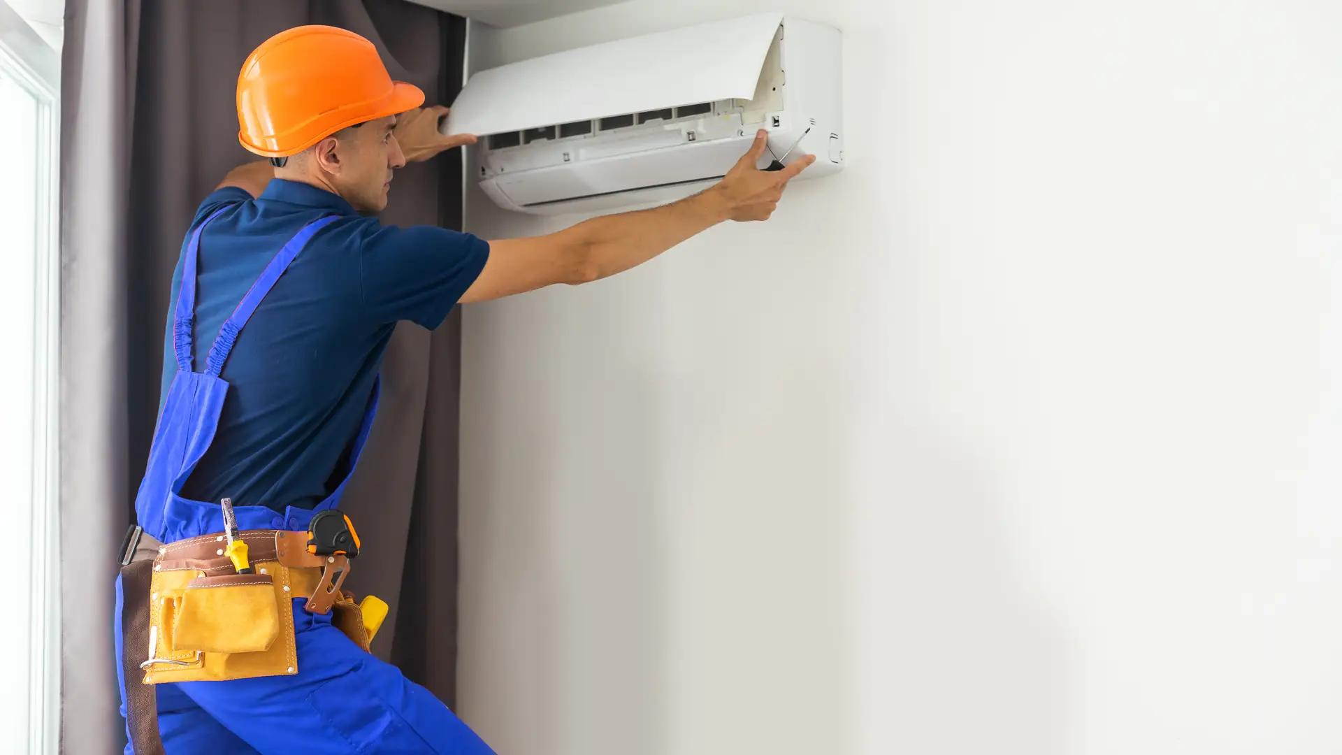 Installateur au travail sur une unité murale à Saint-Raphaël